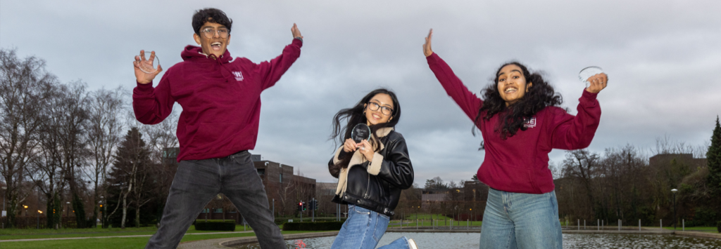 3 TECS awards winners jumping for joy at 2024 ceremony while holding their trophies. Location: Kemmy Business School at the University of Limerick